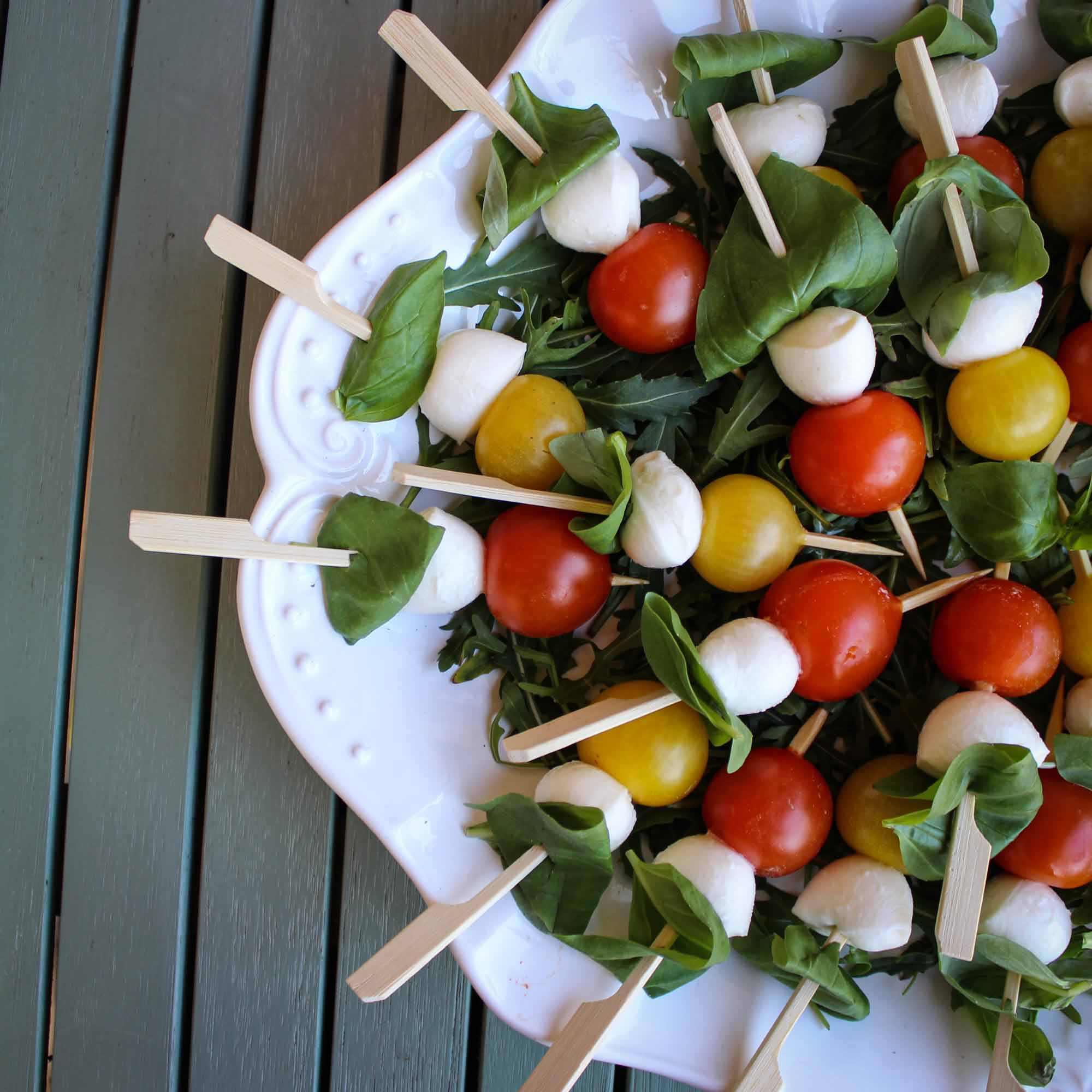 Tomate-Mozzarella-Spieße auf Rucola